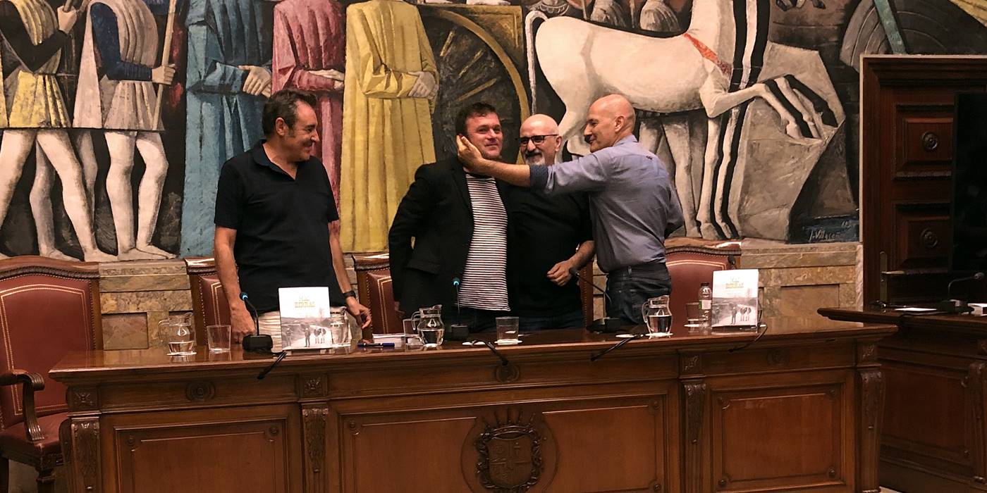 El autor Jorge Martínez abrazado por tres ex-componentes de Más Birras en el acto de presentación del libro 'Más Birras. Del barrio a la leyenda'.